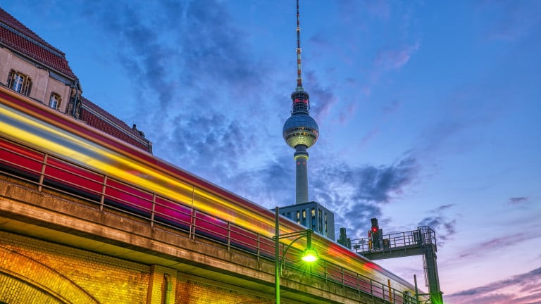 Local train with motion blur and the famous Television Tower in Berlin at night